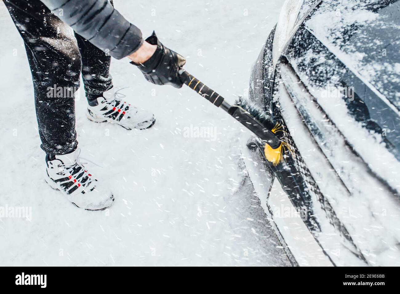 Morgendliche Schneeräumung - ein Mann reinigt das Auto vor Die Reise -  Kaltstart im Winter Stockfotografie - Alamy