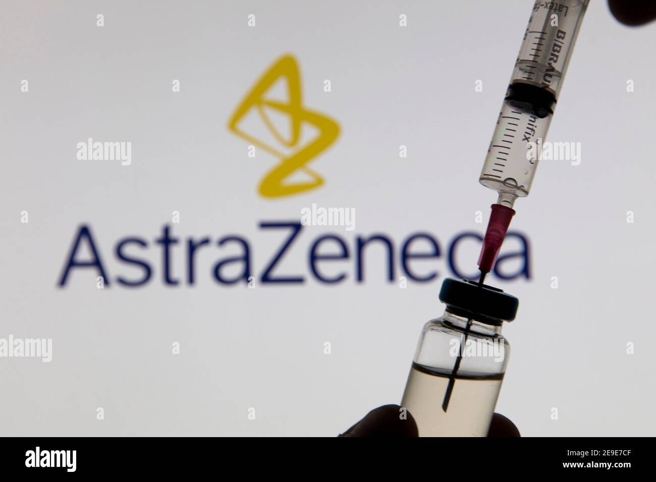 OXFORD, Großbritannien - Februar 2020: Covid-Impfstoffspritze vor dem AstraZeneca-Logo Stockfoto