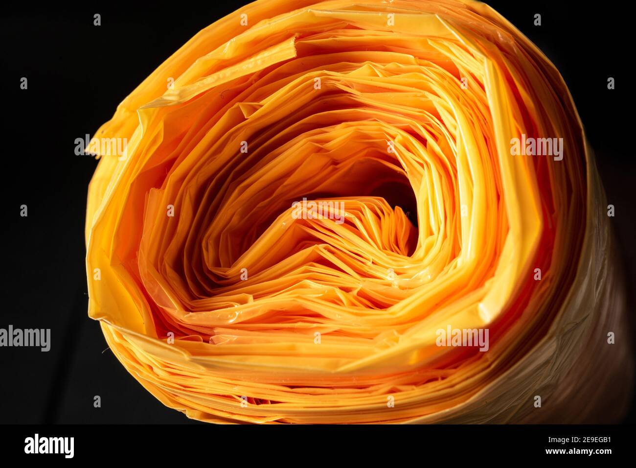 Eine Rolle oranger Plastiktüten als Nahaufnahme mit vielen Schichten. Stockfoto