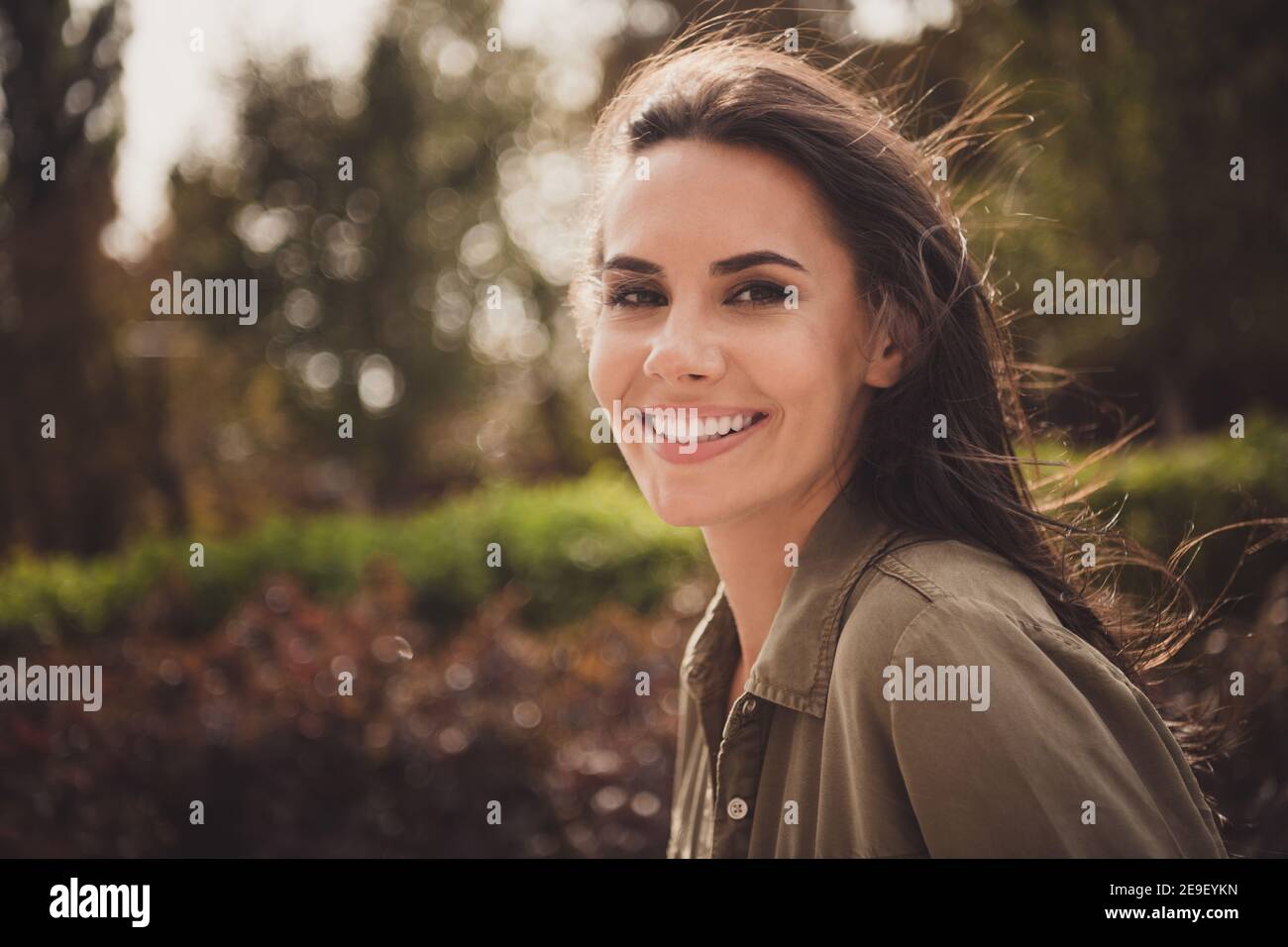 Foto von positiven lustig charmant junge Dame schauen Kamera strahlend Lächeln tragen braune Hemd Park Straße draußen Stockfoto