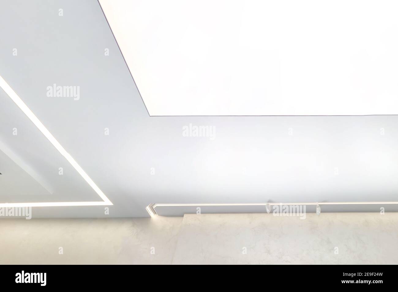 Abgehängte Decke mit Halogenspots Lampen und Trockenbau in leerem Raum in Wohnung oder Haus. Stretch Decke weiß und komplexe Form., sus Stockfoto