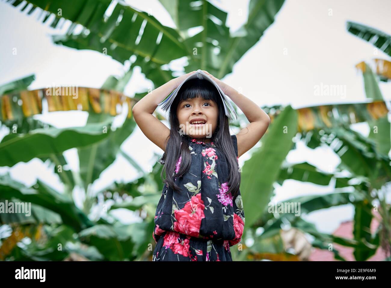 Portrait von niedlichen Mädchen Spaß nach dem Studium und das Lesen eines Buches zu Hause Garten, zu Hause Schule Konzept Stockfoto