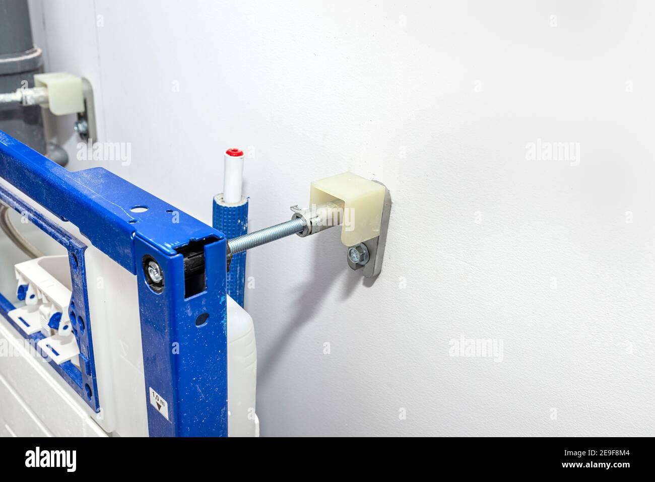 Neu installierter WC-Unterputz-Rahmen für die Wandtoilette, verschraubt an Wand und Boden. Stockfoto