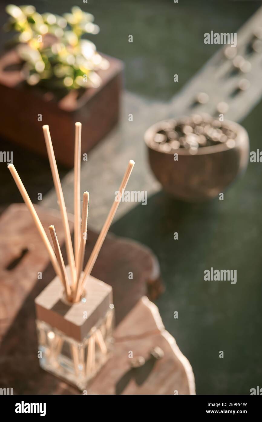 Lufterfrischer mit Bambusstäbchen mit Parfüm in Glas auf dunklem texturiertem Hintergrund.belebender Kaffeeduft. Dunkler Hintergrund. Geröstete Kaffeebohnen in Stockfoto