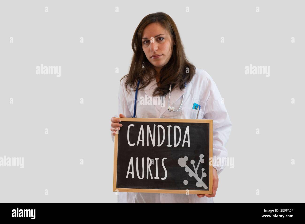 Ärztin hält Tafel mit Candida auris darauf geschrieben. Candida auris ist die neue Welt Pandemie-Infektion. Stockfoto