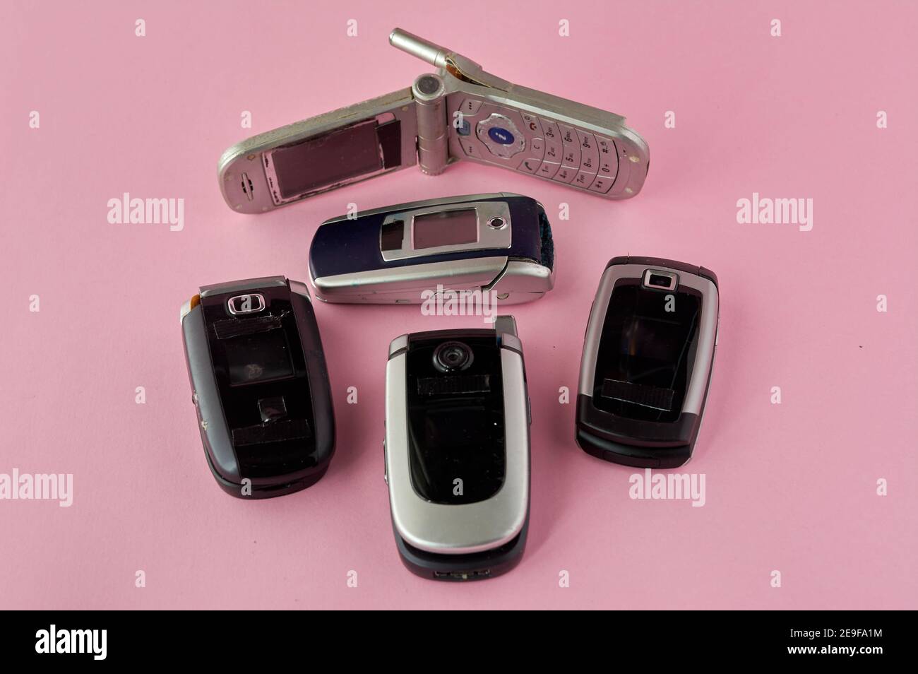 Kaputte Handys, Recycling-Technologie, Anfang 2000er Jahre auf rosa Hintergrund und Kopieplatz,. Stockfoto