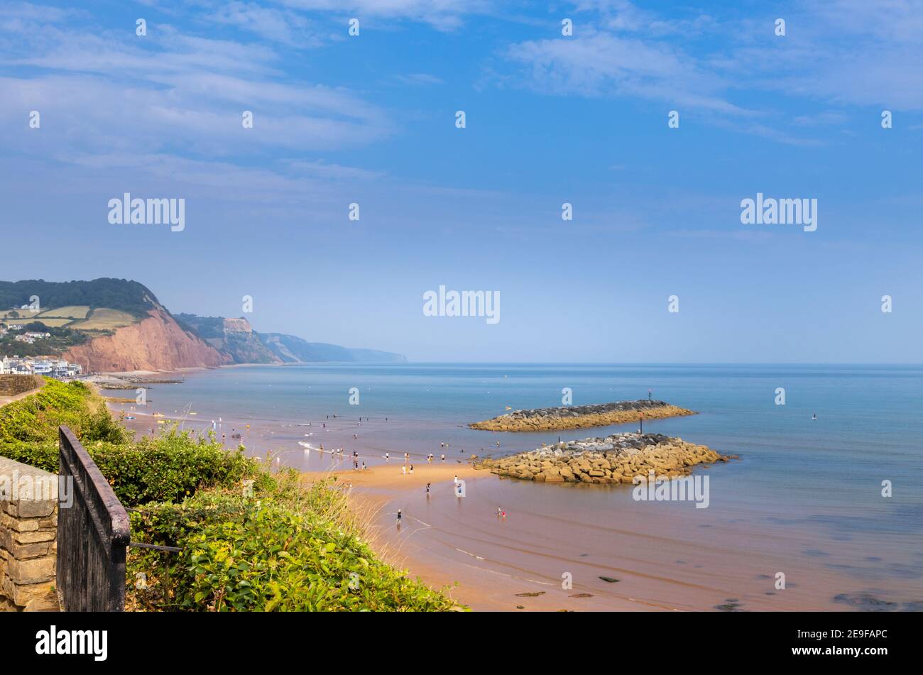 Der Sandstrand und die felsigen Inseln mit Blick nach Osten auf Sidmouth, eine Küstenstadt von Devon am Weltkulturerbe der Jurassic Coast bei Ebbe an einem sonnigen Tag Stockfoto