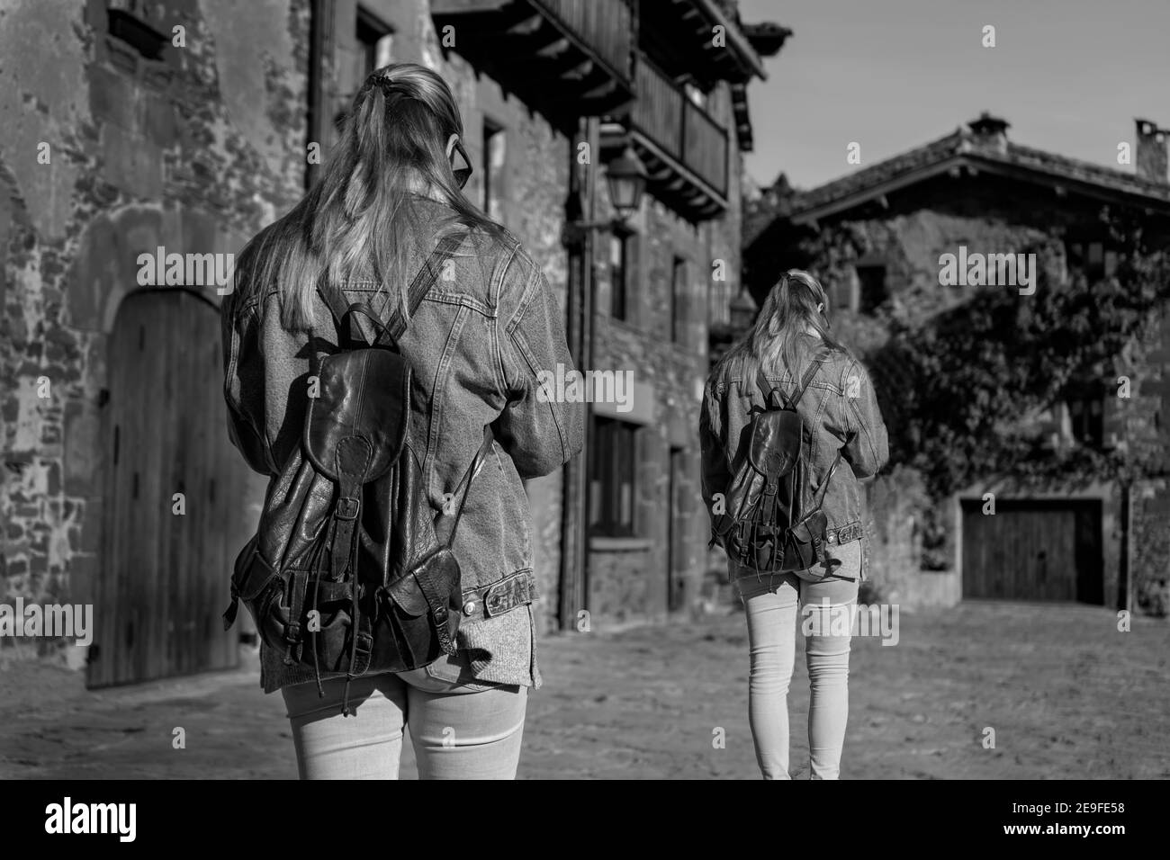 Rückansicht von zwei Frauen zu Fuß in alten mittelalterlichen Dorf.dupliziertes Modell, Klon junge Mädchen in Rupit, Barcelona, Spanien.Kreatives Reisen und Gehen li Stockfoto