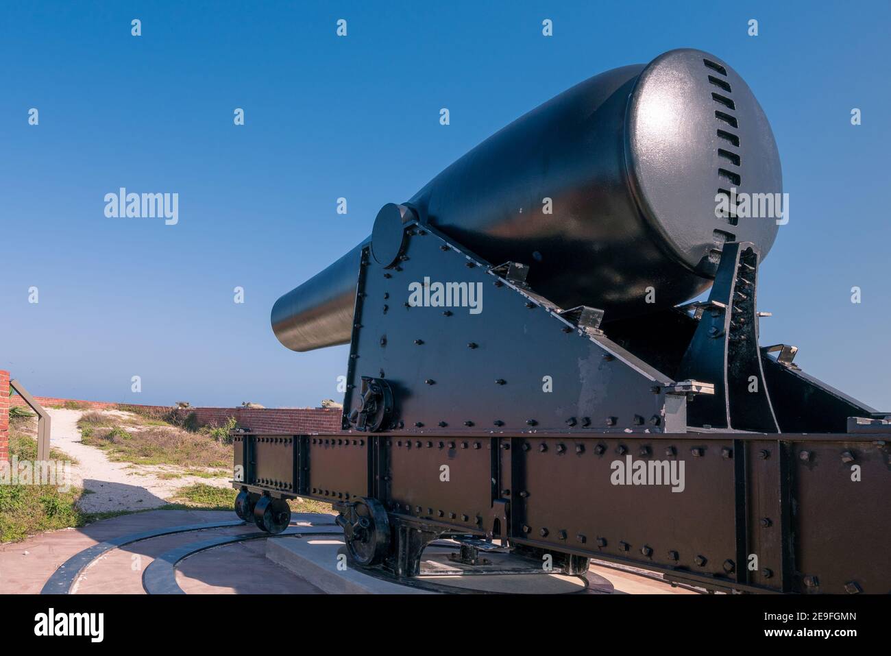 Große alte schwarze Kanone auf einem Stahlwagen mit Rädern. Alte militärische Festung in Florida an einem Sommertag. Stockfoto