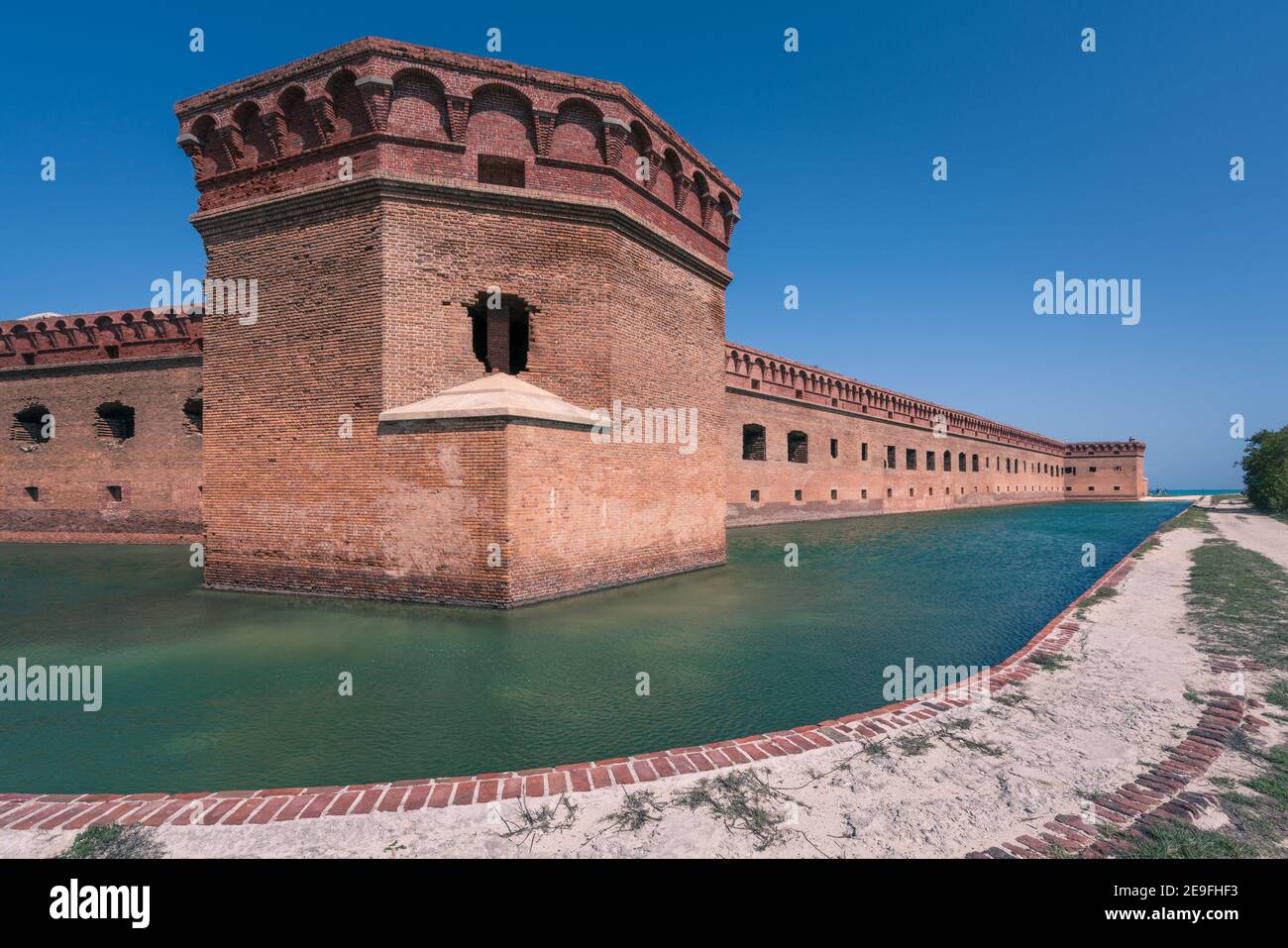 Hohe Backsteinmauern eines alten Militärfests auf einer Insel von Dry Tortugas. Florida. Blauer Himmel, grünes Wasser, schöner Sommertag. Stockfoto