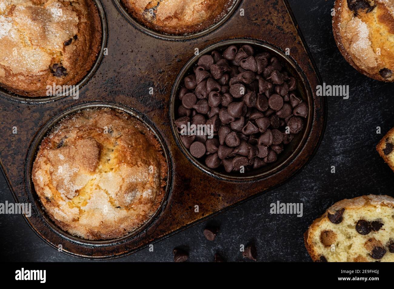 Frisch gebackene Schokoladen-Chip-Muffins und Schokoladenchips in einem Muffin-Dose Stockfoto
