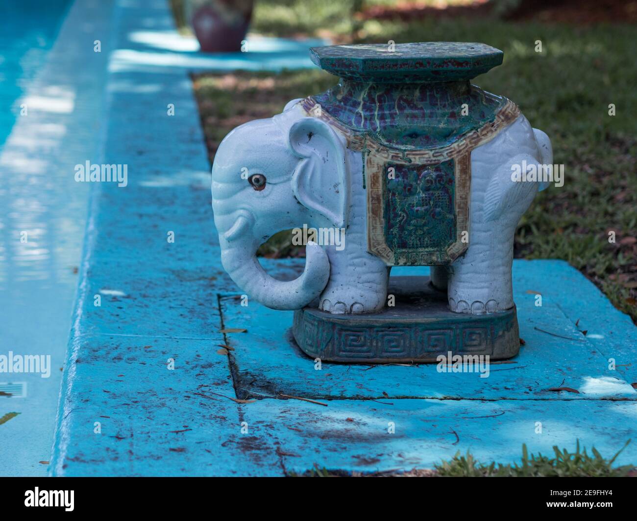 Eine kleine blaue Keramik Elefantenstatue am Pool. Stockfoto