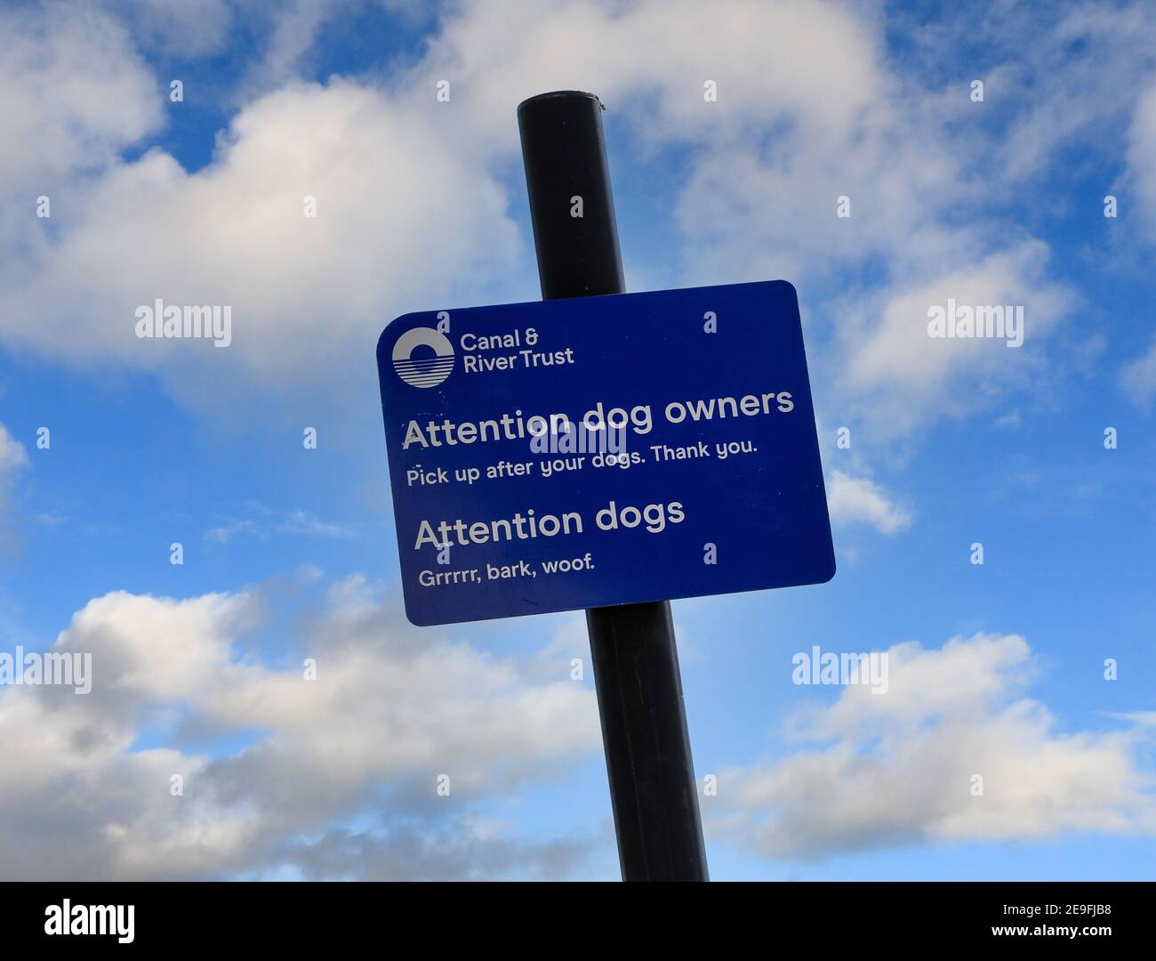 Ein Schild vom Canal and River Trust mit der Aufschrift "Achtung Hundebesitzer, holt nach euren Hunden, danke" und "Achtung Hunde, Grrrrr, Barke, woof" Stockfoto