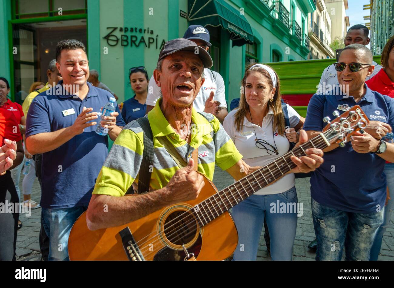 Kubanischer Straßenmusiker, der in der Altstadt von Havanna mit einer Gruppe von Touristen, Kuba, unterwegs ist Stockfoto