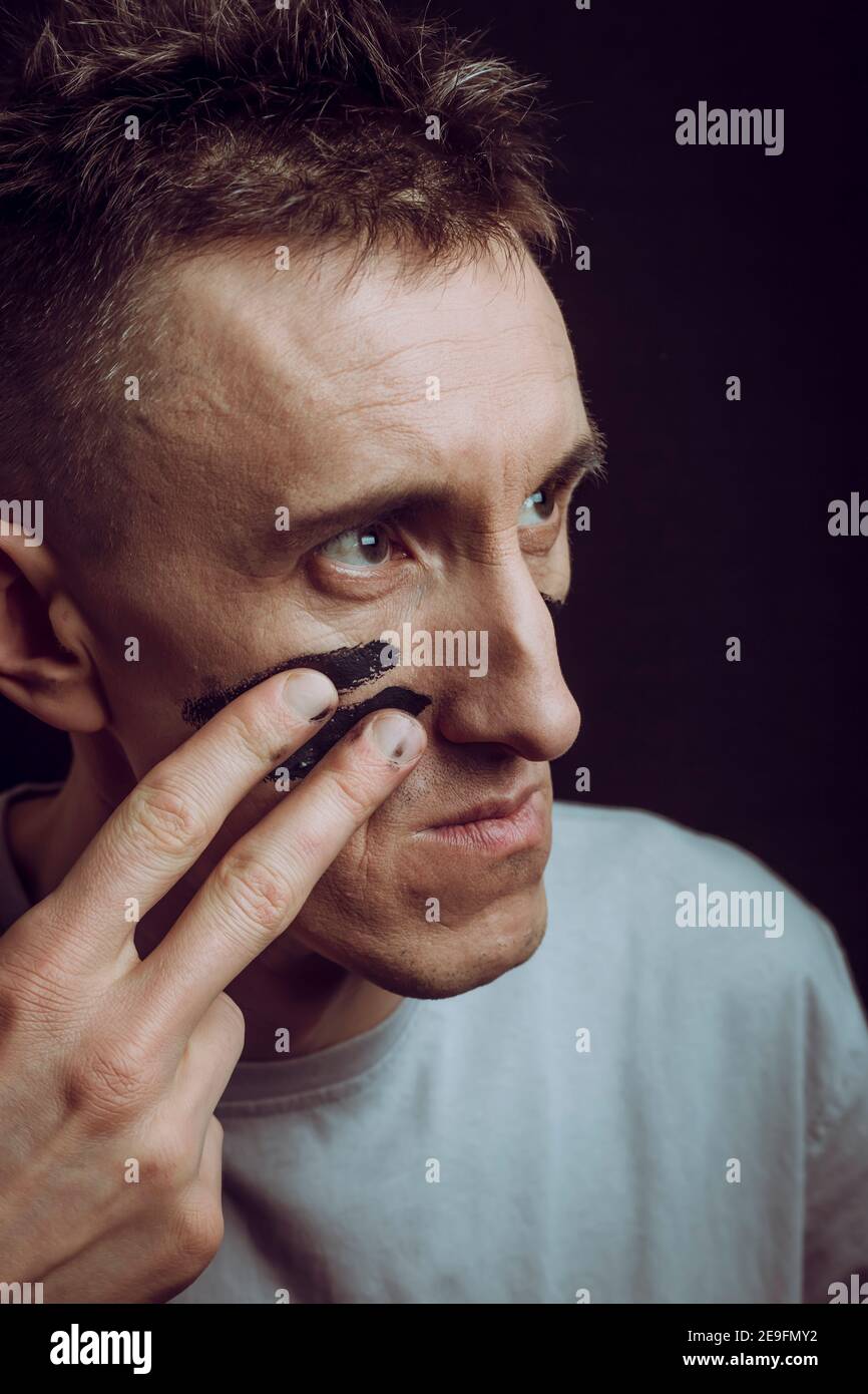 Ein Mann mit militärischer Farbe auf seinem Gesicht. Kriegserklärung. Stockfoto