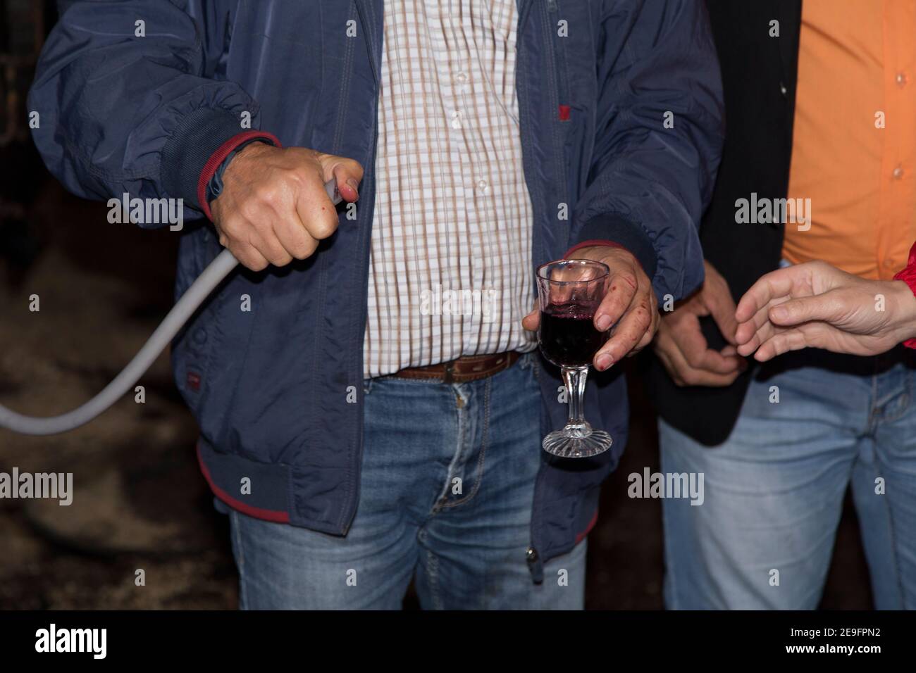 Weinprobe in der Bodega der moldawischen Winzer. Weinproduzent mit Klemmbrett Inspektion Weinflaschen auf Regalen im Weinkeller. Stockfoto