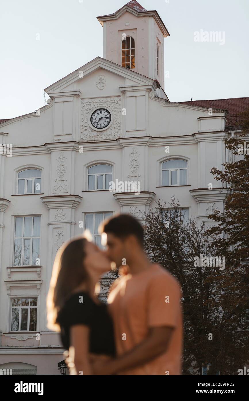 Verschwommener Mann und Frau küssen sich am Hintergrund des alten Gebäudes. Verliebte Paare in der Stadt. Urbane Liebesgeschichte Stockfoto