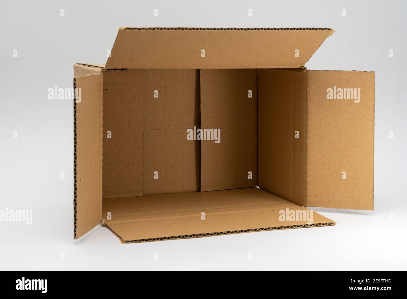 Karton-Versandkarton vor einem weißen neutralen Hintergrund. Perfekt für die Verpackung für die Lieferung. Leerer brauner offener Karton Stockfoto