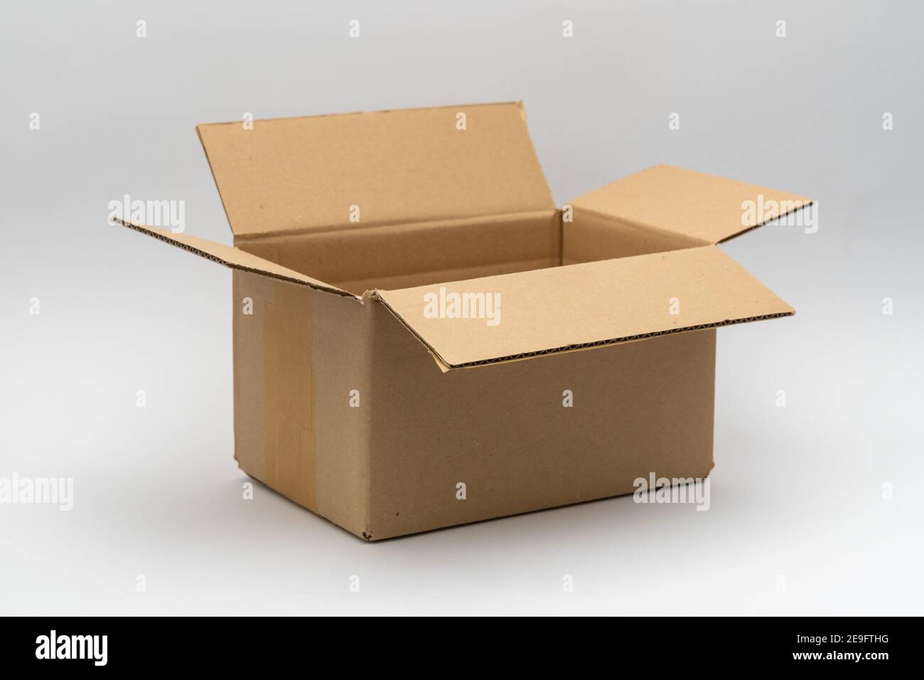 Karton-Versandkarton vor einem weißen neutralen Hintergrund. Perfekt für die Verpackung für die Lieferung. Leerer brauner offener Karton Stockfoto
