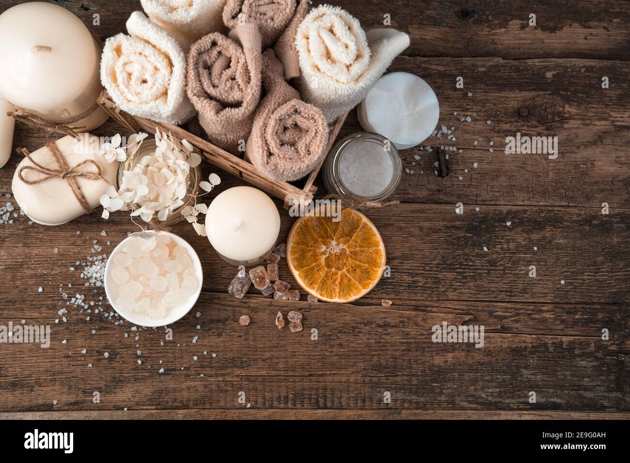 Spa Komposition mit Kerzen, Seife und Servietten auf braunem Holzgrund. Stockfoto