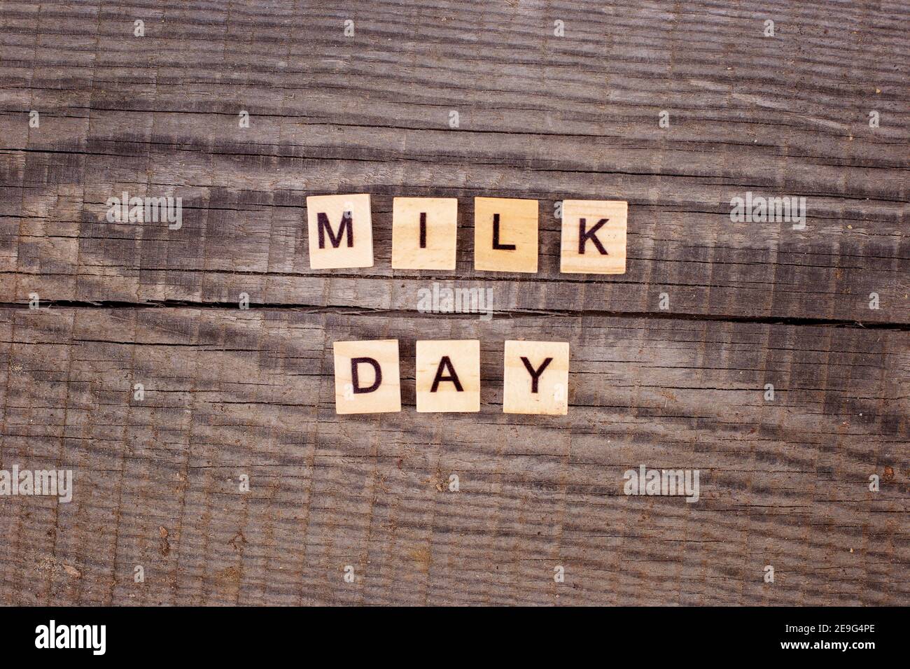 Holzbriefe Milch Tag auf alten hölzernen Hintergrund mit Stockfoto