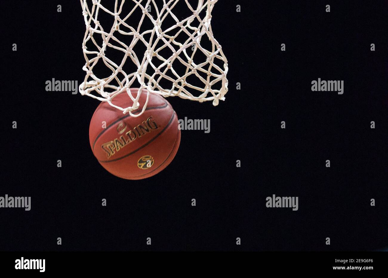 Basketball-Netz Nahaufnahme mit Ball und schwarzem Hintergrund. Stockfoto
