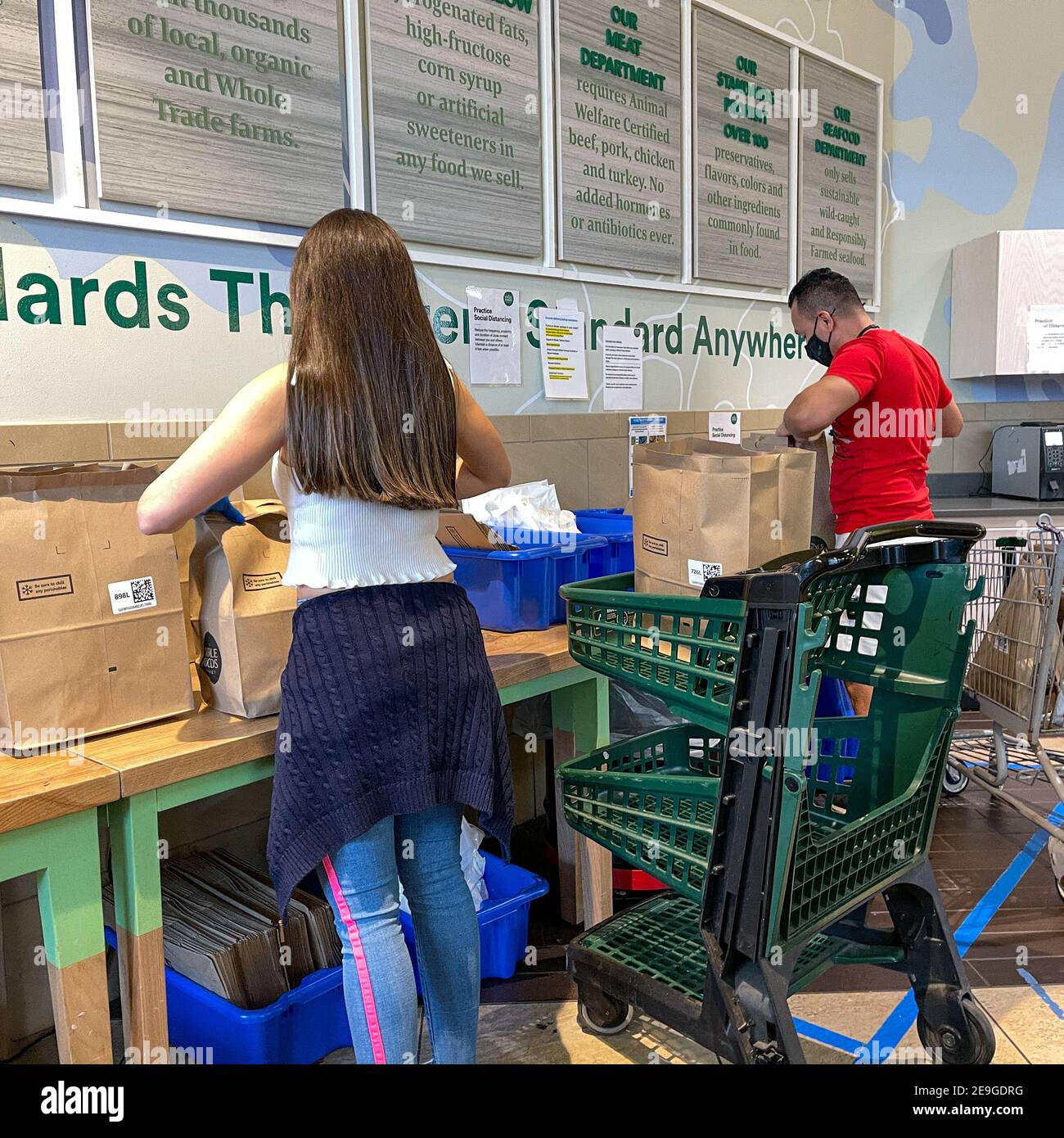 Orlando, FL USA - 24. Januar 2021: Amazon Prime Fresh Mitarbeiter überprüfen und Absacken ihrer Bestellungen in einem Whole Foods Lebensmittelgeschäft. Stockfoto