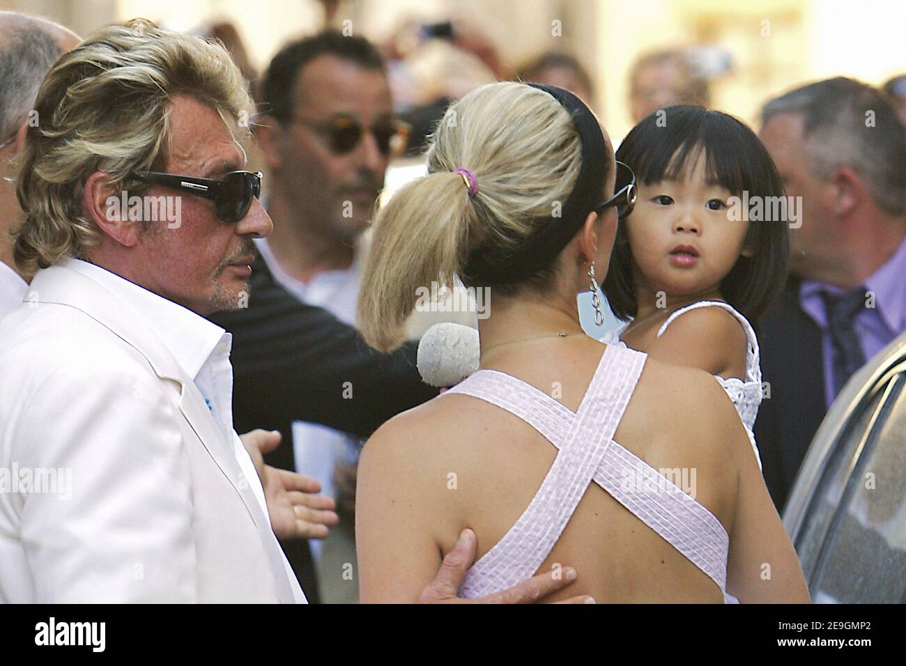 Der französische Sänger Johnny Hallyday mit seiner Frau Laeticia und ihrer Tochter Jade kommt am 29. Juli 2006 zur Feier der Hochzeitszeremonie des französischen Schauspielers Jean Reno mit dem französisch-amerikanischen Model Zofia Borucka in das historische Dorf 'Baux-de-Provence', Südfrankreich. Foto von Nebinger-Holubowicz ABACAPRESS.COM Stockfoto