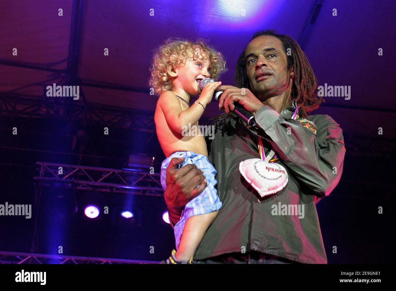 Der französische Sänger und ehemalige Tennisspieler Yannick Noah tritt am 30. Juli 2006 mit seinem Sohn Joalukas beim "Vendanges du Coeur" (Traubenherz) in Ouveillan bei Montpellier, Frankreich, auf. Er ist Versteigerer von Wein der Genossenschaft von Ouveillan, um von der Vereinigung 'Les Restos du coeur' zu profitieren. Foto von Pascal Parrot/ABACAPRESS.COM Stockfoto