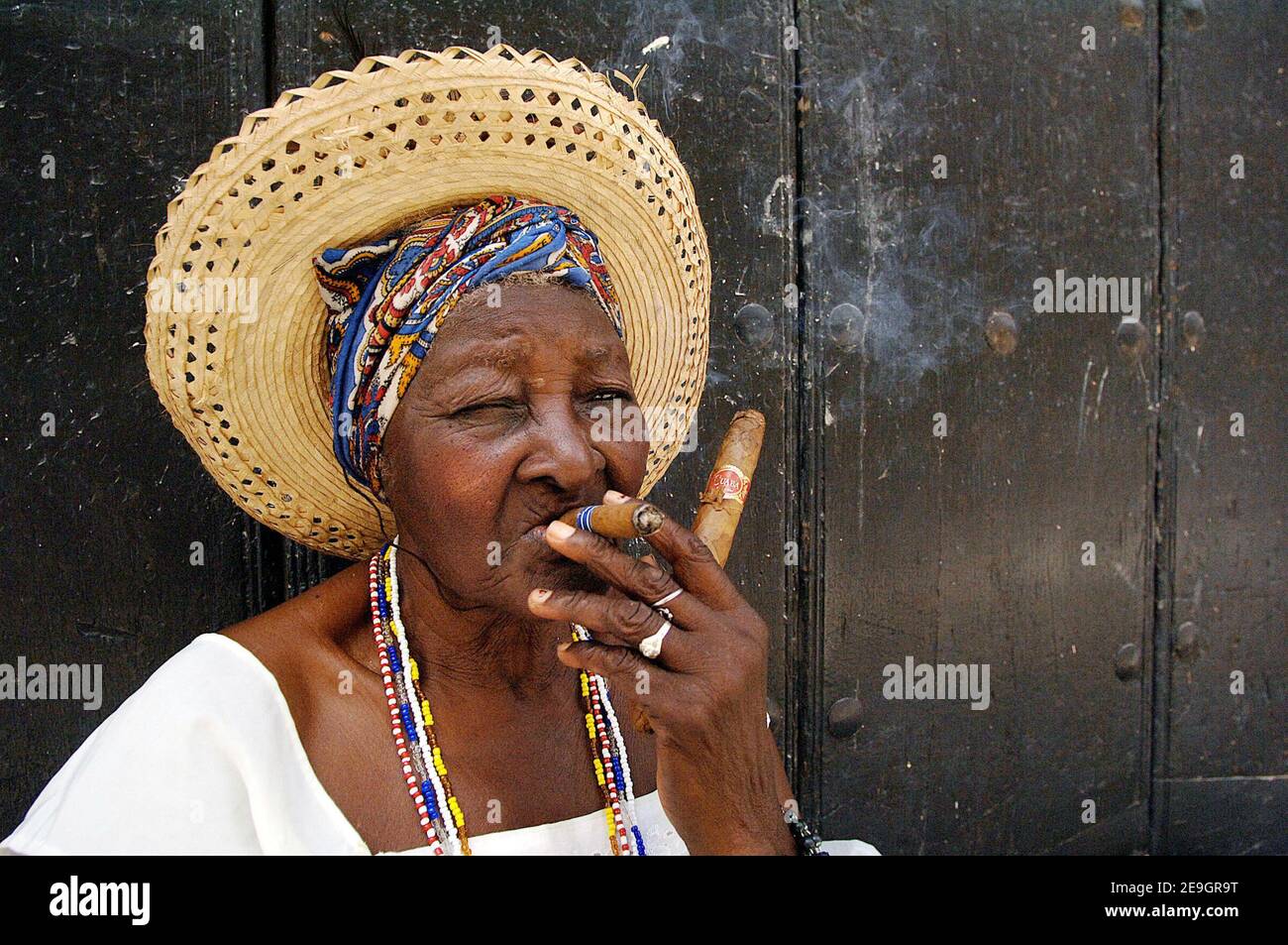 Eine Habanera, die auf einer Straße in Havanna, Kuba, eine Zigarre raucht, am 6. August 2006, sechs Tage nachdem Fidel Castro seinem Bruder Raul die provisorische Kontrolle über die Regierung übergab, die er seit 47 Jahren ununterbrochen geführt hat. Die kubanischen Bürger warten darauf, herauszufinden, ob der 'Lider Maximo' nach seiner Genesung von einer Darmoperation wieder die Führung übernehmen wird. Foto von ABACAPRESS.COM Stockfoto