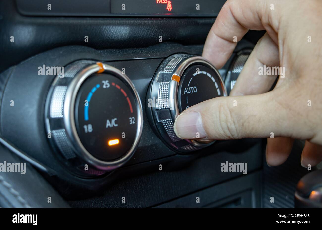 Mit Klimaanlage in einem Auto, Nahaufnahme. Die Hand manipuliert den Lüftungsregler im Fahrzeug. Stockfoto