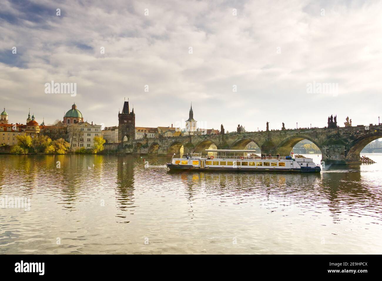 2019 11, Praha, Tschechien. Blick auf die Moldau in Prag mit einem Touristenboot und der Karlsbrücke im Hintergrund Stockfoto