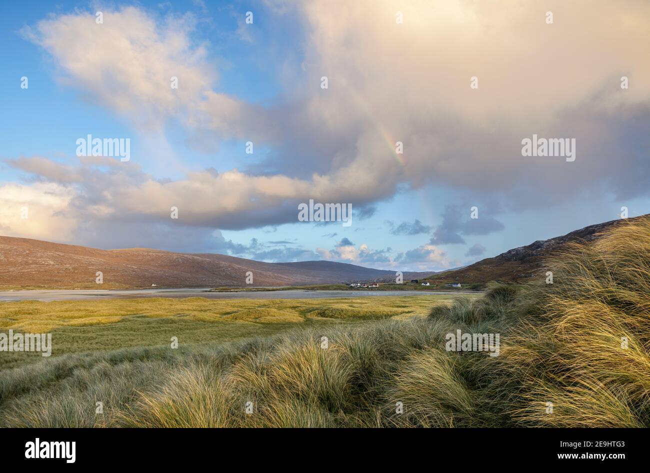 Isle of Lewis and Harris, Schottland: Regenbogenwolken und Regenbogen über den Dünengräsern in der Nähe von Luskentire Beach auf South Harris Island Stockfoto