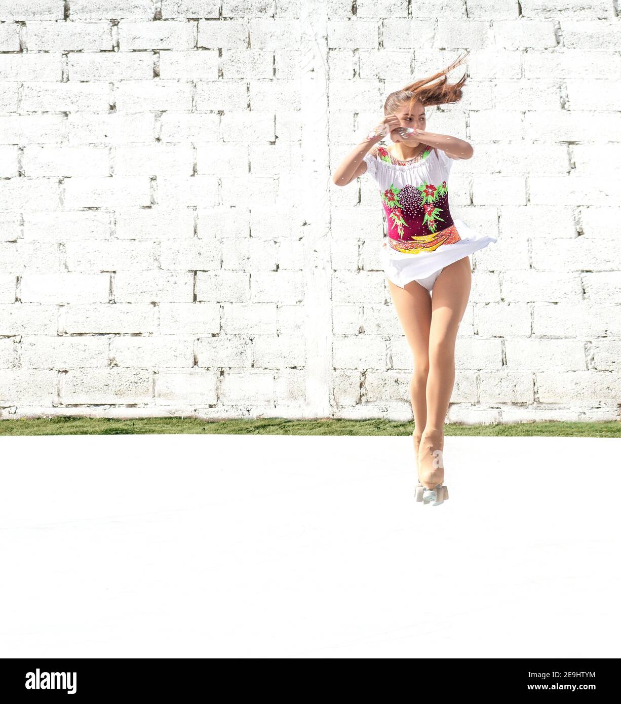 Teenager Mädchen Durchführung eines Flip-Sprung auf Quad Roller Schlittschuhe Im Freien Stockfoto