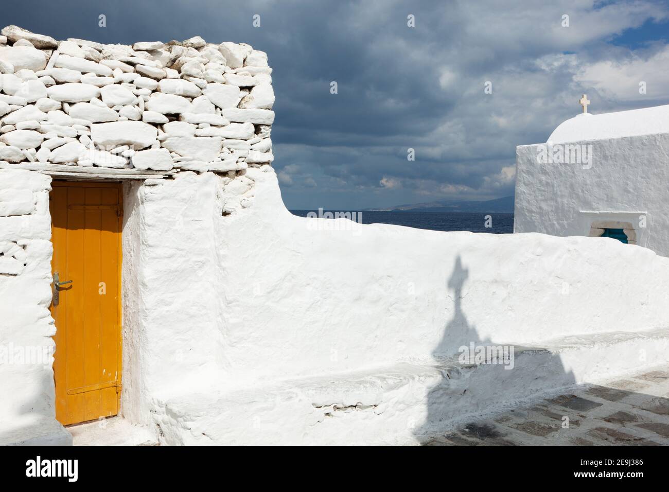 Mykonos, Griechenland Traditionelles Haus und gelbe Tür im Schatten der Kirche Panagia Paraportiani in Mykonos-Stadt. Stockfoto