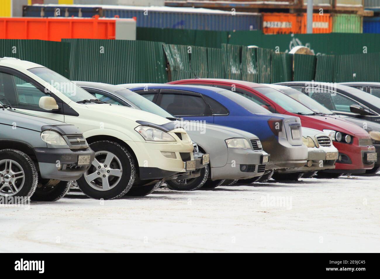 12.05.2020 Syktyvkar, Russland, Offener Parkplatz mit einer Reihe von Autos auf dem Hintergrund eines Winter städtischen Umwelt. Stock Foto mit leerem Platz für Text und Design. Stockfoto