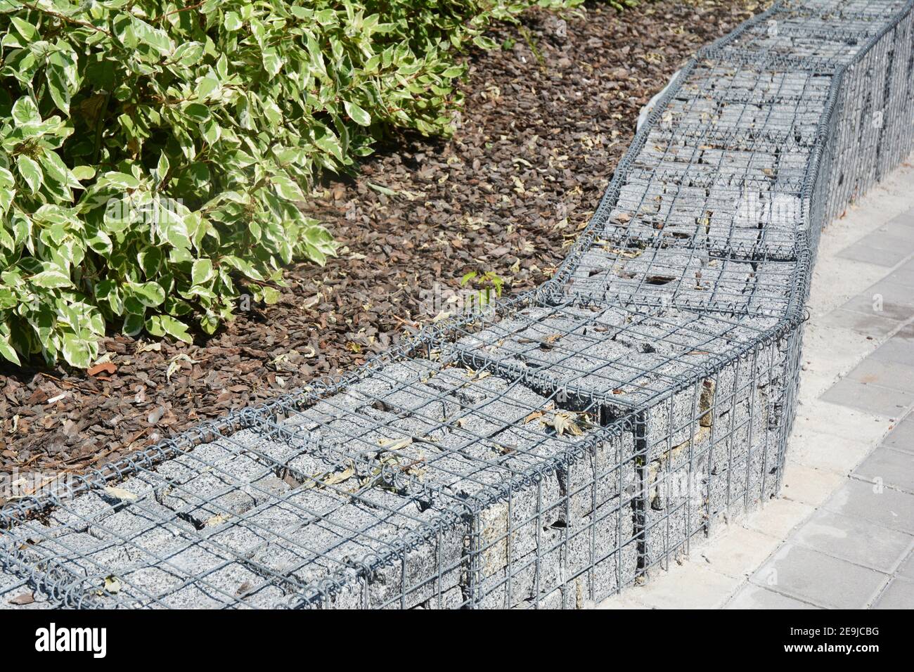 Moderner Gabion Zaun mit Steinen in Drahtgeflecht. Gabion Drahtgefecht mit Natursteinen. Landschaftsdesign. Stockfoto