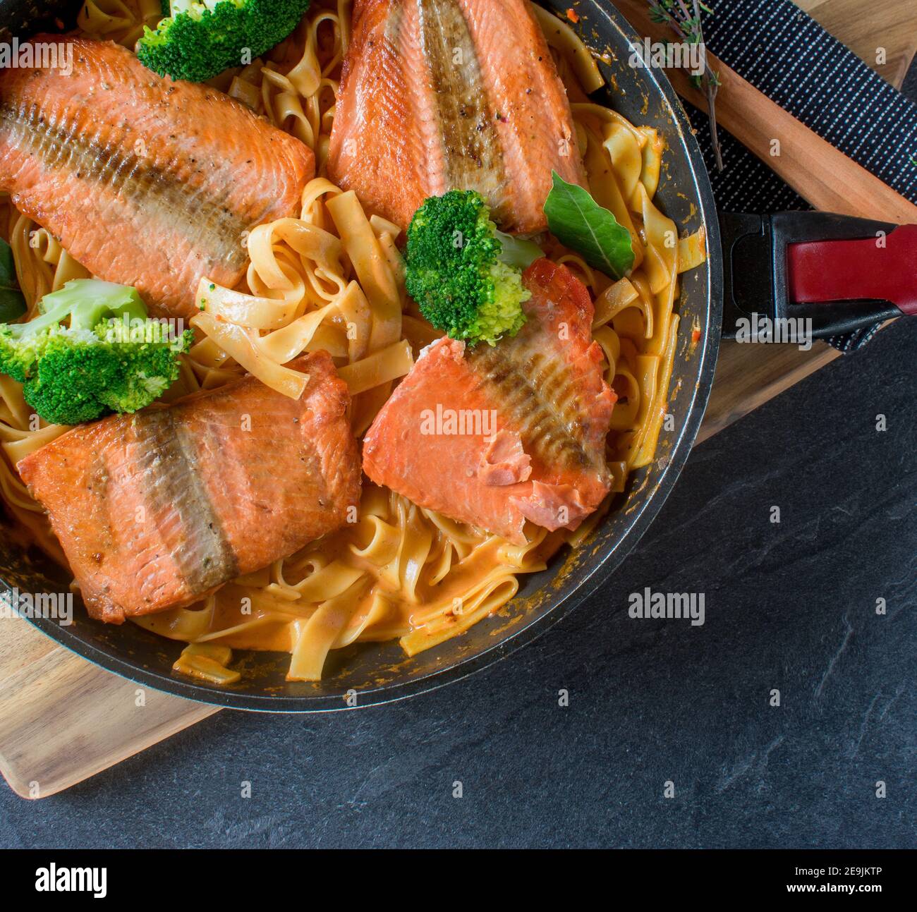 italienisches Fischgericht mit gebratenem Lachs, Pasta und Sahne-Sauce von oben mit Kopierplatz Stockfoto