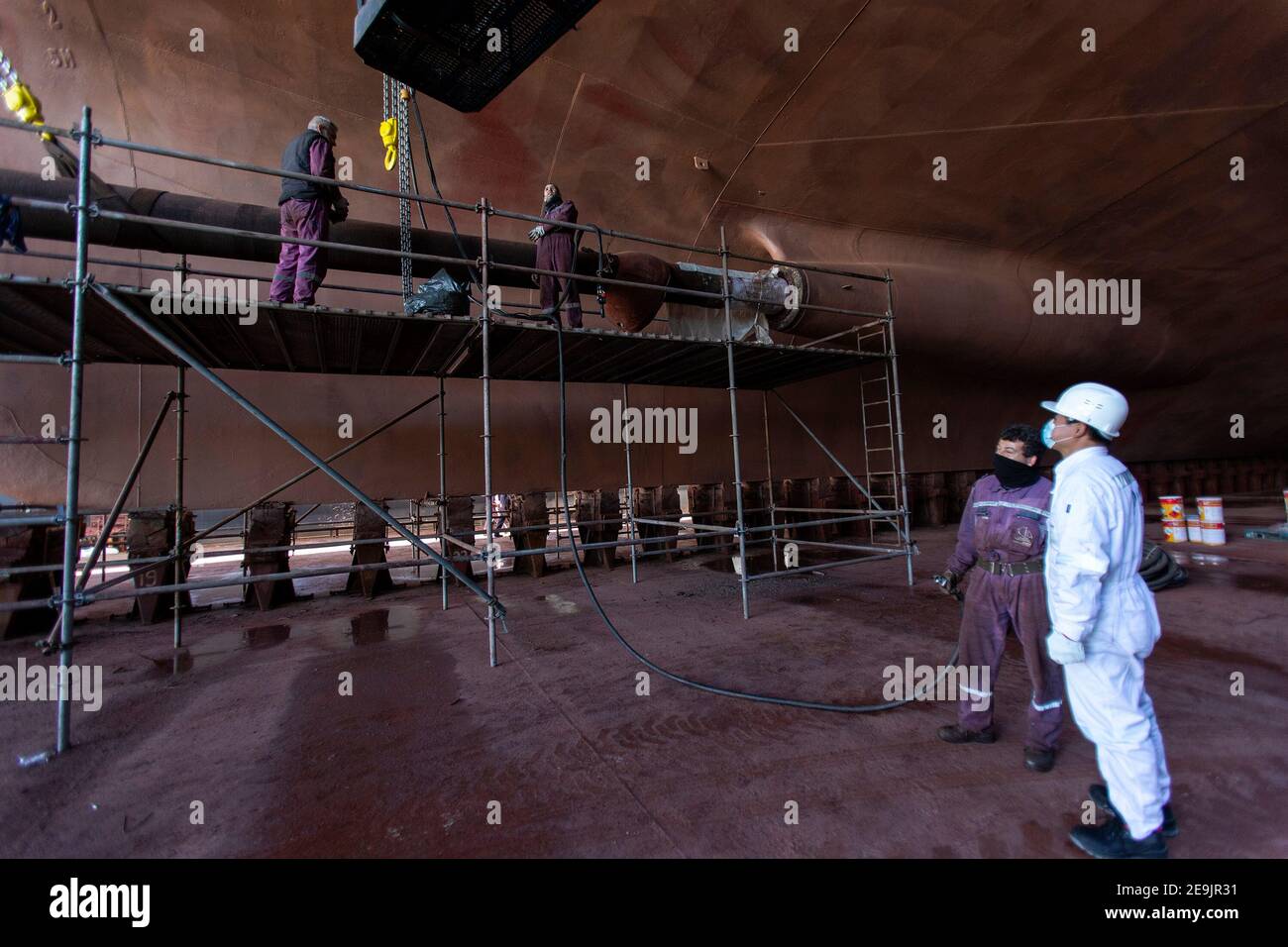 (210205) -- ATHEN, 5. Februar 2021 (Xinhua) -- der chinesische Angestellte Ma Liang (1st R) inspiziert die Schiffsreparaturarbeiten in der Schiffsreparaturzone im Hafen von Piräus, Griechenland, 3. Februar 2021. Während das Frühlingsfest oder das chinesische Mondneujahr vor der Tür steht, bleiben chinesische Mitarbeiter, die im Ausland arbeiten, immer noch an ihren Posten im Hafen von Piräus. Die chinesische COSCO Shipping Group erwarb 2016 nach einer internationalen Ausschreibung die Mehrheit der Anteile der Piraeus Port Authority S.A. (PPA), während die Tochtergesellschaft des chinesischen Unternehmens, Piraeus Container Terminal S.A. (PCT), das Containerterminal des Hafens verwaltet Stockfoto