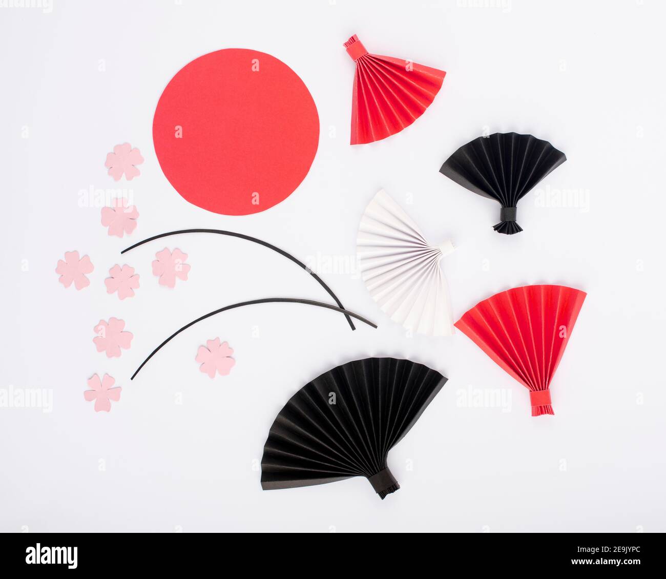 Rote Sonne, rosa Blumen und Origami-Papier Fan isoliert auf weißem Hintergrund. Papierdesign für Japan National Foundation Tag. Stockfoto