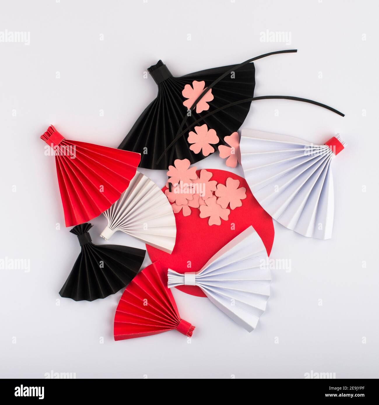 Rote Sonne, rosa Blumen und Origami-Papier Fan isoliert auf weißem Hintergrund. Papierdesign für Japan National Foundation Tag. Stockfoto