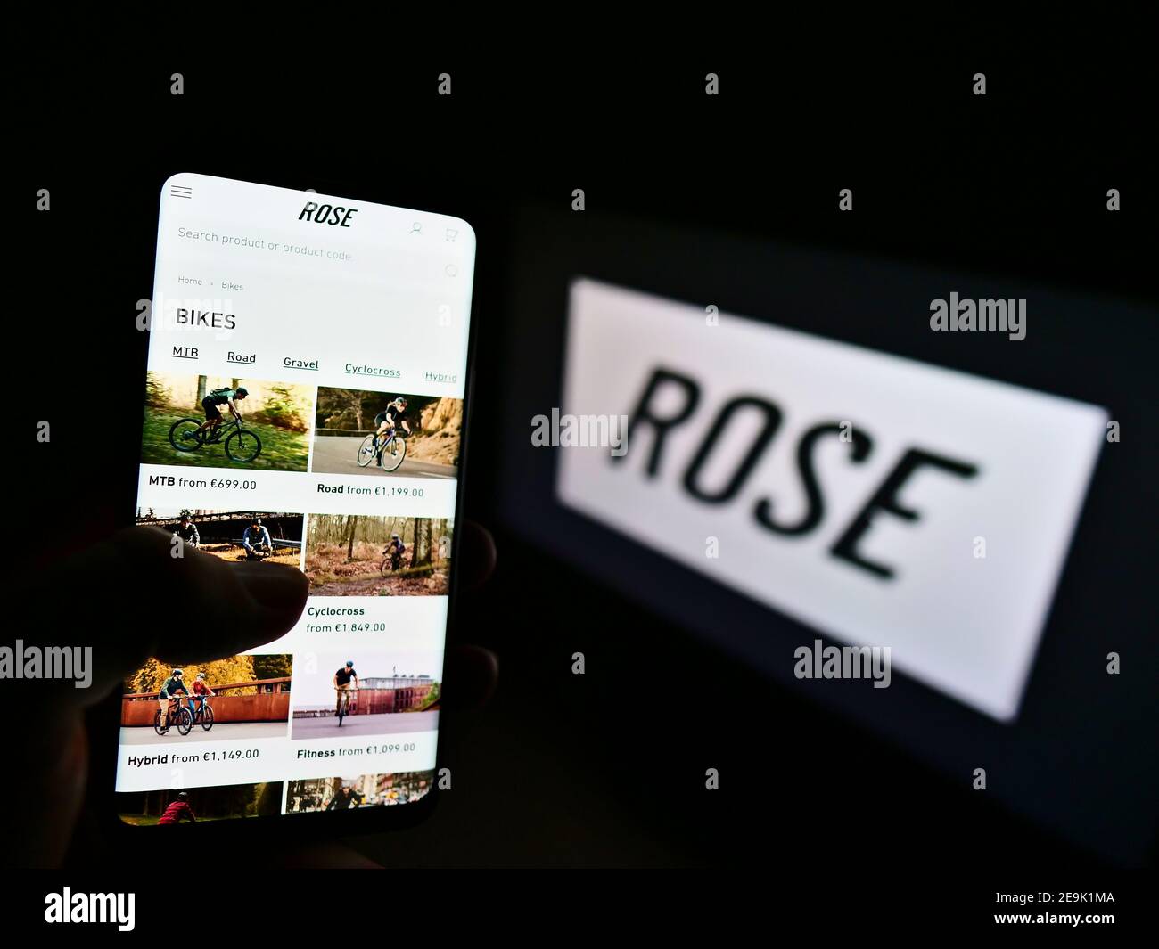 Handyhalter mit Online-Shop des deutschen Fahrradherstellers Rose Bikes GmbH auf dem Display mit Logo. Konzentrieren Sie sich auf die Mitte links des Telefonbildschirms. Stockfoto