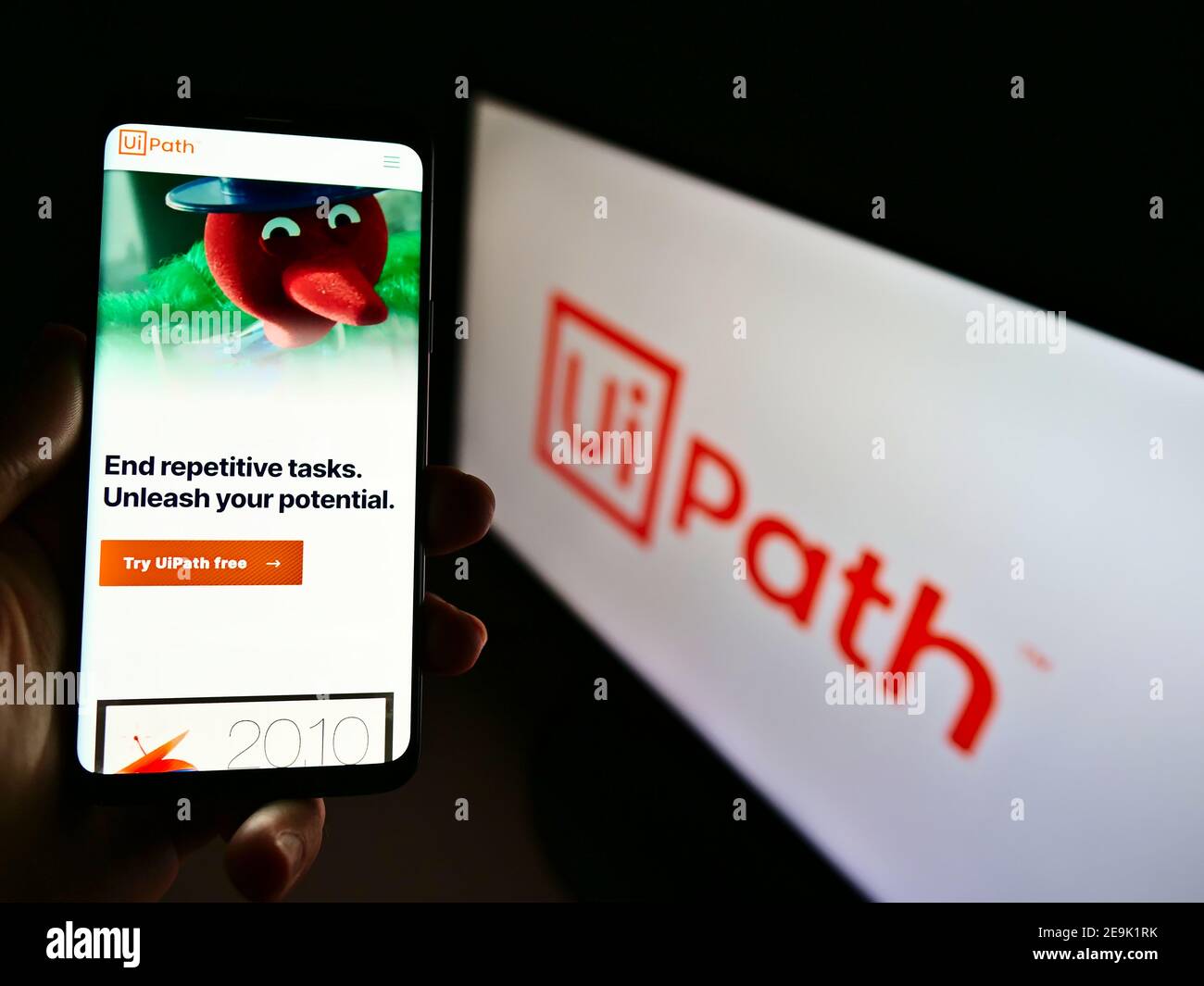 Person hält Handy mit Website der Software-Entwicklung Unternehmen UiPath Inc. Auf dem Display vor dem Logo. Konzentrieren Sie sich auf die Mitte des Telefonbildschirms. Stockfoto