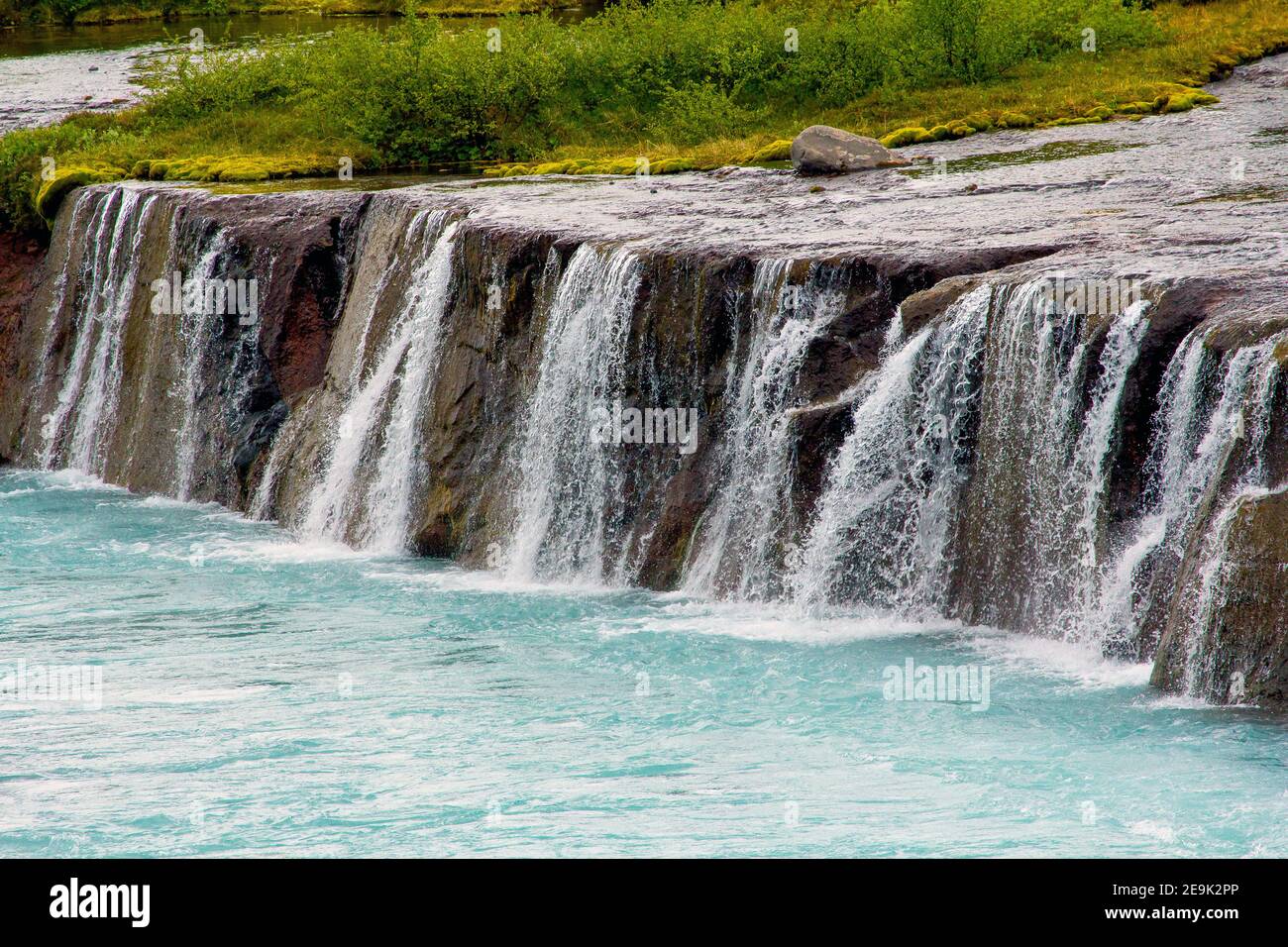 Hraunfossar mehr als Miniatur-Wasserfälle von Bächen über eine Entfernung von etwa 900 Metern aus dem Hallmundarhraun gebildet. Die Wasserfälle Stockfoto