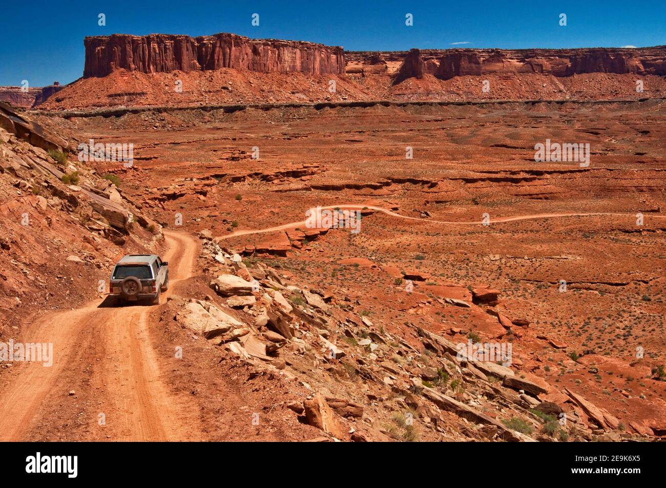 Geländewagen auf der White Rim Road, in Murphy Hogback, Murphy Point Cliffs in der Ferne, Canyonlands National Park, Utah, USA Stockfoto