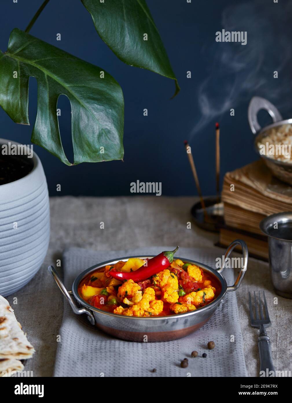 Aloo gobi traditionelle indische Gerichte aus Blumenkohl und Kartoffeln mit rotem Chili, serviert mit braunem Reis, Zitronenwasser und Chapati auf dem Tisch Stockfoto