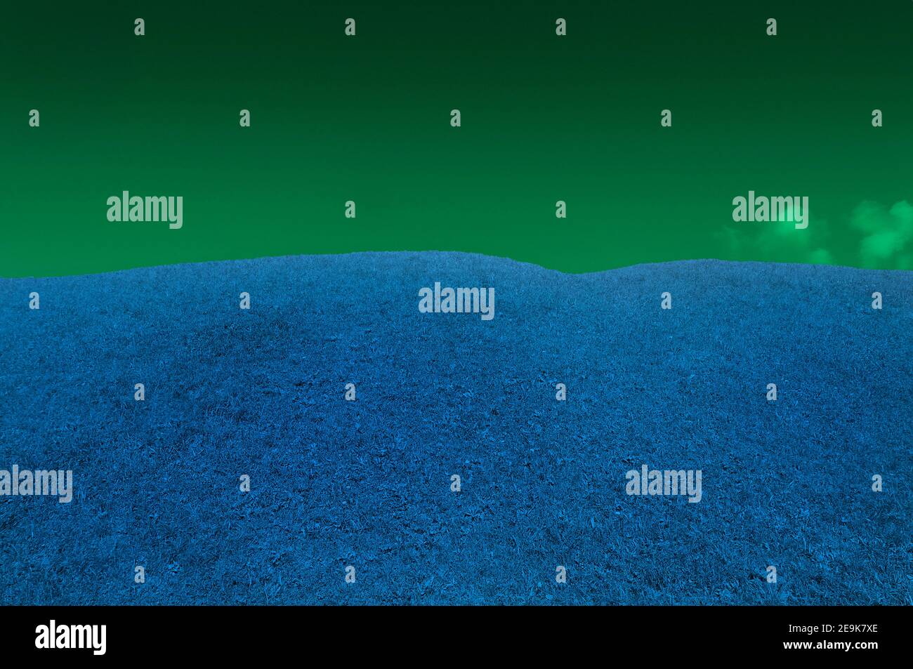 Panoramablick auf einen grasbewachsenen Hügel mit einer unwahrscheinlichen Farbe Stockfoto