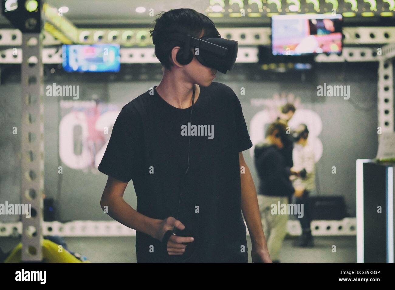 Guy in Virtual Reality Brille in hellen modernen Quest Zimmer. Aufregende Technologie. Technologie in realer Umgebung. Stockfoto