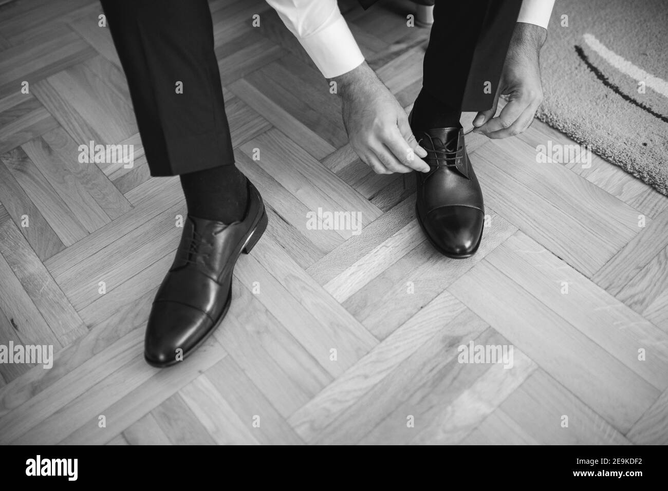 Bräutigam bindet seine Schuhe und bereitet sich auf die Hochzeit Stockfoto