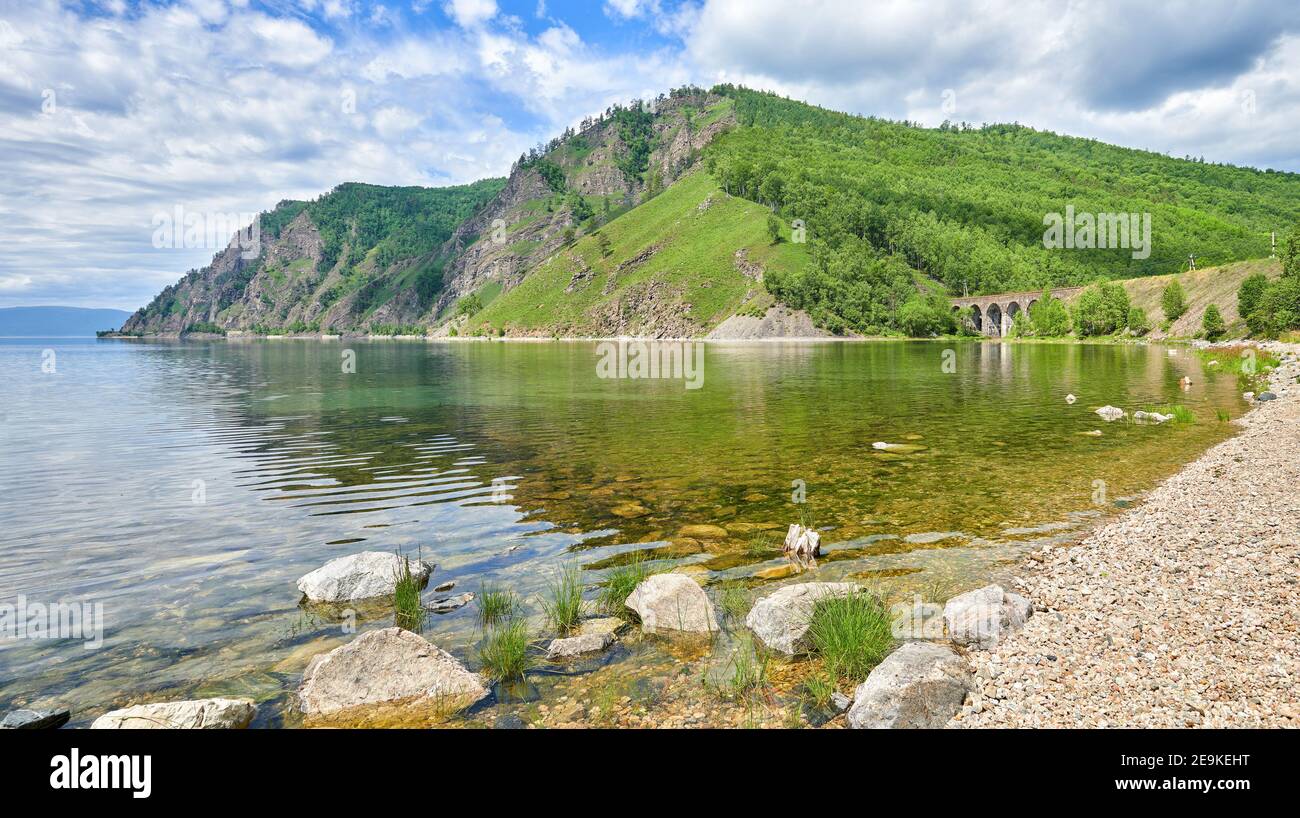 Klares Wasser in der Bucht des Baikalsees. Landschaft mit einem steinernen Bogenviadukt der Circum-Baikalbahn. Region Irkutsk. Ostsibirien Stockfoto